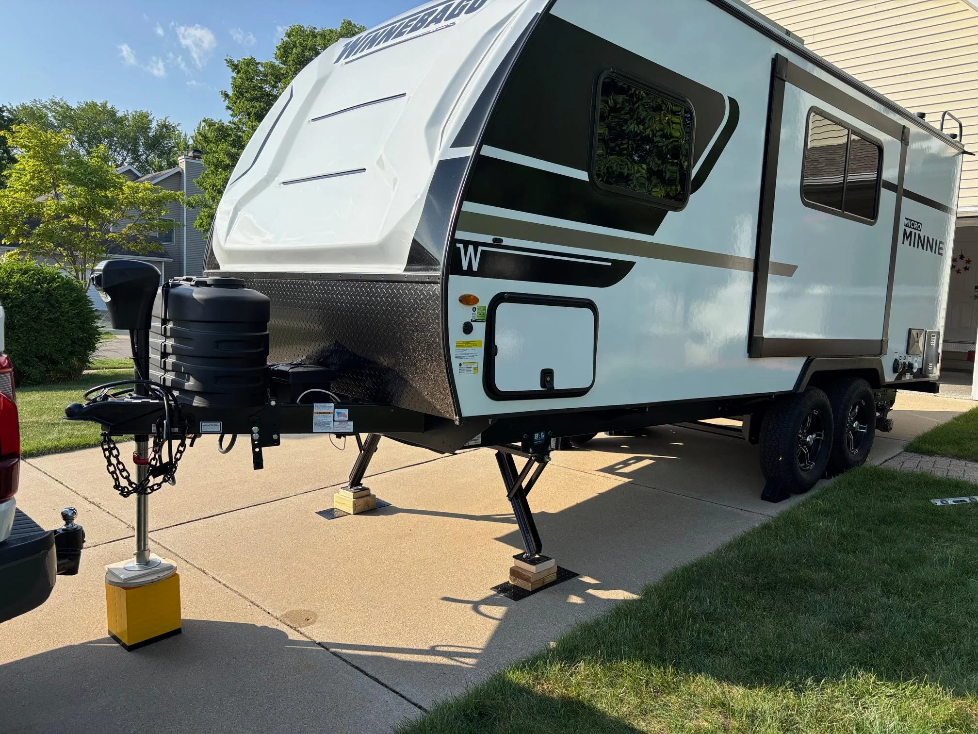 A travel trailer hitched to a pickup truck sitting level on a flat driveway with the rig aligned straight